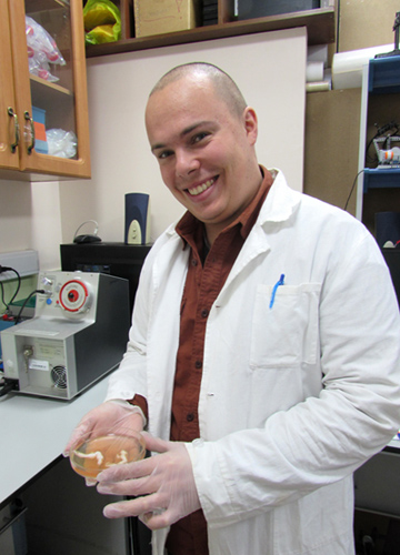 Один из авторов работы – Дмитрий Ивлев – держит в руках чашку Петри с фибриновыми тромбами из экспериментальной системы